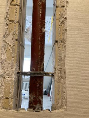 Ein Rohr in der Wand mit Durchblick in den Raum